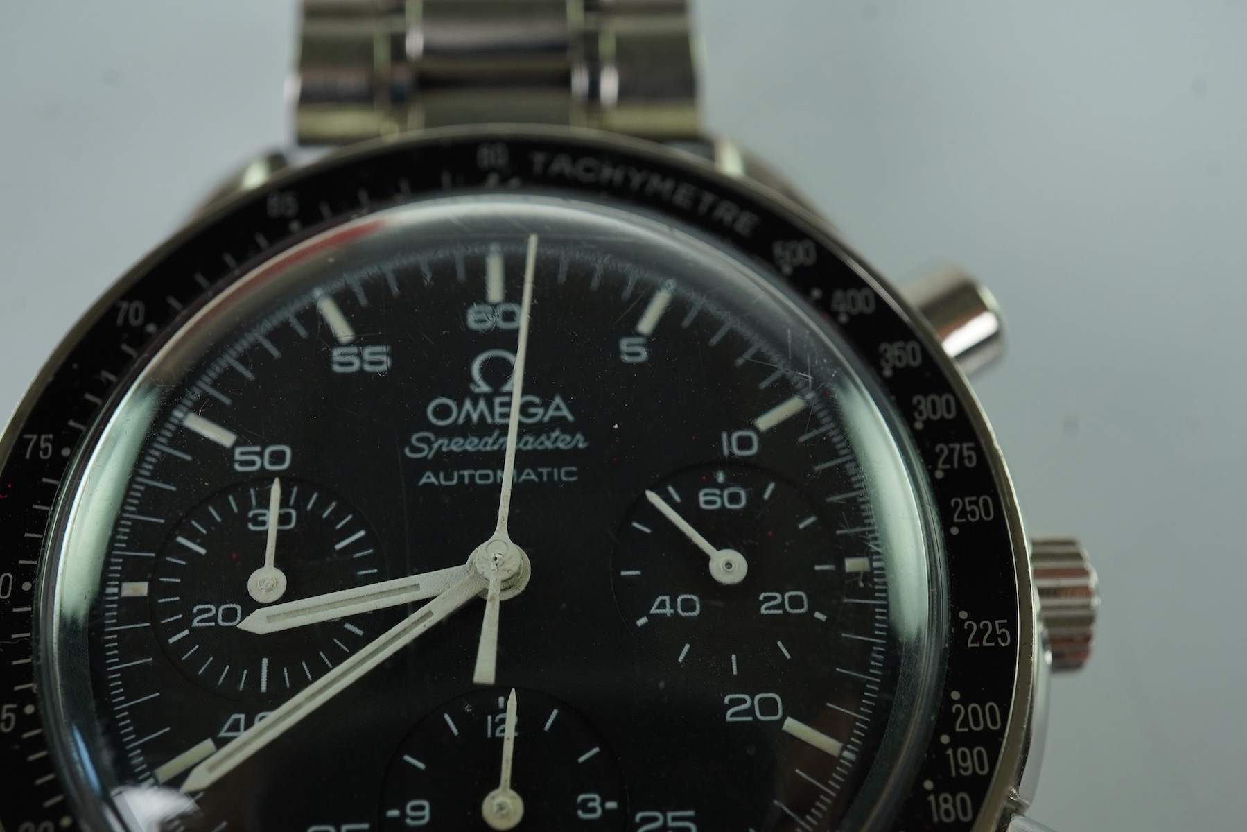 A gentleman's late 1990's stainless steel Omega Speedmaster automatic wrist watch, with box and three pamphlets